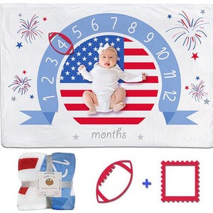 May include: A white milestone blanket featuring a red, white, and blue American flag circle, numbers 1 through 12, and fireworks graphics. Includes a folded blanket, a red football-shaped marker, and a red square frame for tracking months.