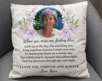 May include: A white square throw pillow featuring a circular portrait of a woman surrounded by light purple lily flowers. The text reads: When you miss me, feeling blue. Look up at the sky, I'm watching you. I LOVE YOU, FOREVER AND ALWAYS Love, Nana.