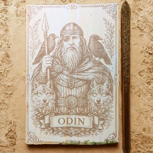 May include: A sepia-toned illustration of Odin, a figure from Norse mythology, holding a spear, with ravens and wolves. The word "ODIN" is displayed on a banner. A long, decorative, wooden sword is on the right.