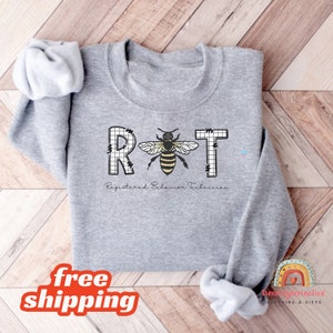May include: Gray sweatshirt with a bee graphic and the text "RBT Registered Behavior Technician".