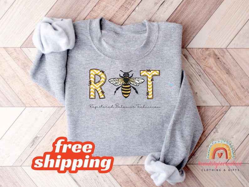May include: Gray sweatshirt with the text "RBT" in yellow and black with a bee graphic. The text below the letters reads "Registered Behavior Technician".