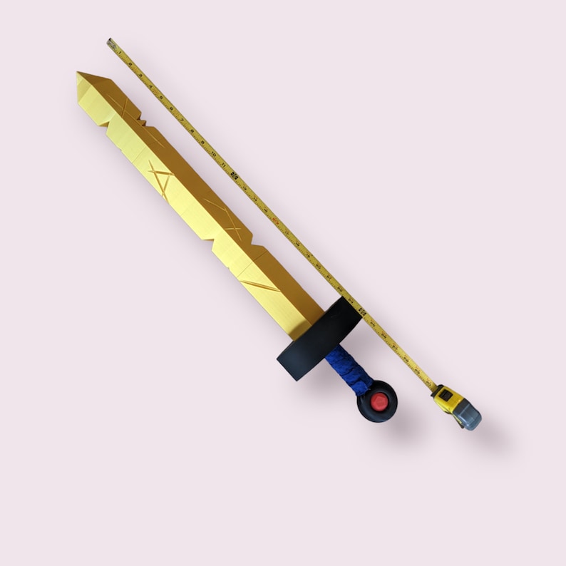 May include: A gold-colored sword with a blue and black handle and a red pommel. A yellow measuring tape is next to the sword, measuring 30 inches.