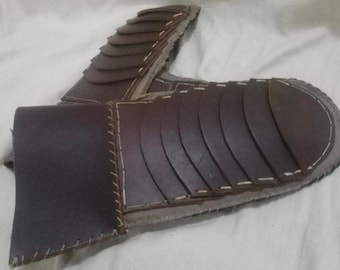 May include: Brown leather armour with a segmented design, stitched together with white thread.