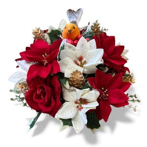 May include: A Christmas floral display with red poinsettias, white flowers, and a small orange bird ornament. Gold pine cones and accents add a festive touch. The arrangement is set against a white background.