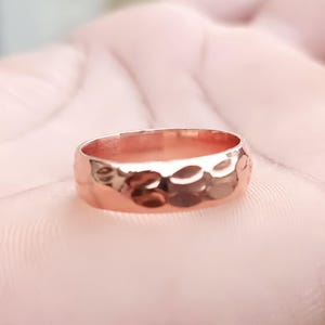 Könnte beinhalten: Ein gehämmerter Bandring aus Roségold.