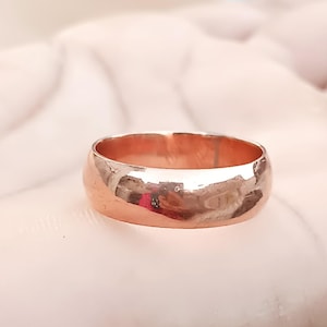 Könnte beinhalten: Ein schlichter, polierter Roségold-Ehering.