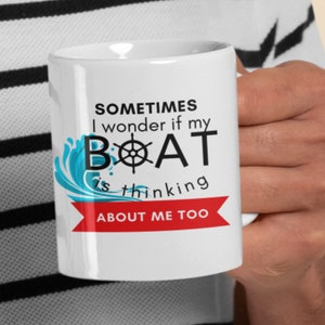 May include: White ceramic coffee mug with a blue and red design. The mug has the text "Sometimes I wonder if my BOAT is thinking ABOUT ME TOO" printed on it.