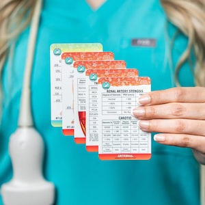 May include: A set of five rectangular medical reference cards featuring diagnostic tables for renal artery stenosis and carotid artery measurements. The cards display printed text, numerical data, and anatomical diagrams with orange and white headers.