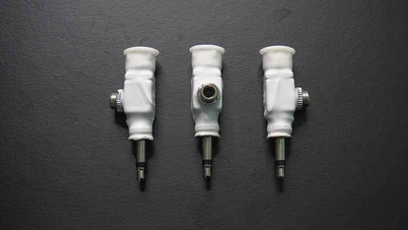 Pode incluir: Tr&ecirc;s adaptadores de &aacute;udio de cer&acirc;mica branca com pontas de metal prateadas. Os adaptadores t&ecirc;m uma extremidade rosqueada e um pequeno furo no centro.