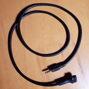 May include: A black audio cable with a 3.5mm jack on one end and a round connector on the other end.