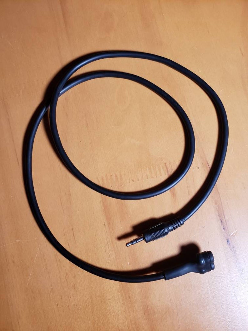 May include: A black audio cable with a 3.5mm jack on one end and a round connector on the other end.