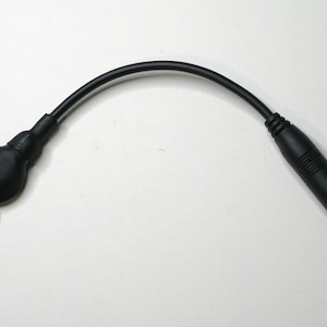 May include: A black audio cable with a 3.5mm jack on one end and a larger jack on the other end.