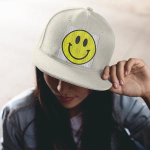Hoed van keperstof met smileygezicht met leren patch