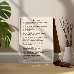 May include: A black and white print of a poem titled "Nirvana" by Charles Bukowski. The poem is about a young man riding a bus through North Carolina and stopping at a cafe in the hills. The poem describes the cafe, the people, and the snow outside.