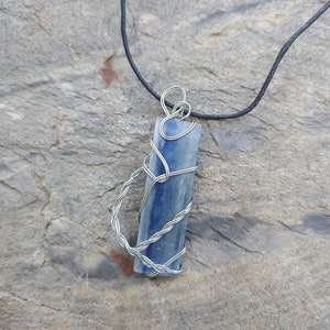 Polished kyanite stone wired with silver colored wire spiraled and braided