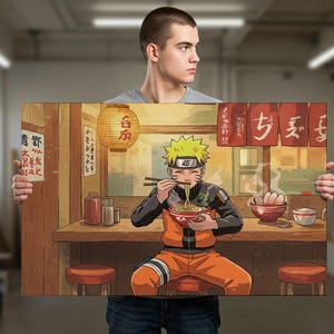 A man is holding up a large poster or painting depicting a character from the anime series Naruto, who is shown eating noodles at a restaurant.