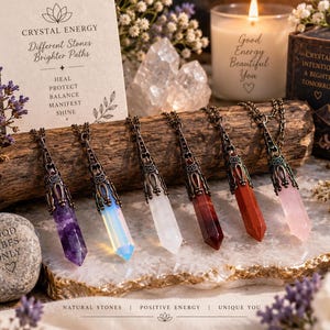 Pode incluir: Seis pingentes de ponta de cristal com tampas e correntes de metal em tom de bronze ornamentado. As pedras incluem ametista roxa, opalita iridescente, quartzo transparente, jaspe vermelho escuro, cornalina laranja e quartzo rosa.