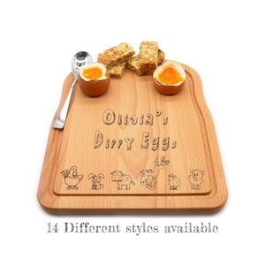 May include: A personalised wooden breakfast board shaped like a slice of bread with the text "Olivia's Dirty Eggs" and a design of farm animals. The board has two egg cups and is perfect for serving a simple breakfast.