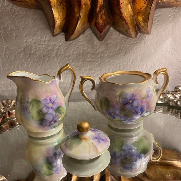 Antique hand painted creamer sugar and scoop gold gilt artist signed with purple violets. Mint condition 3x3”