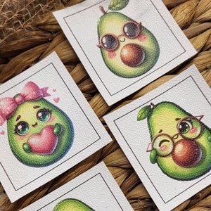 May include: Four square white labels featuring avocado illustrations. Each avocado has a unique design, including sunglasses, glasses, a bow, and a heart. The avocados are green with brown seeds, set against a woven background.