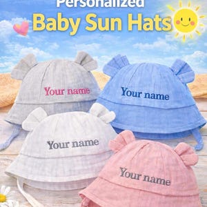 May include: Four personalized baby sun hats in gray, blue, white, and pink. Each hat has ear-like flaps and a chin strap. The text "Your name" is embroidered on each hat. The image also includes the text "Personalized Baby Sun Hats".