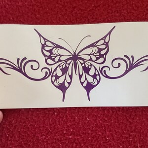 May include: Purple butterfly decal with intricate wing details and swirling vines. The decal is on a white background.