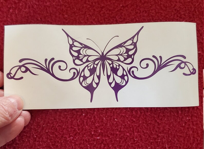 May include: Purple butterfly decal with intricate wing details and swirling vines. The decal is on a white background.