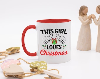 この女の子はクリスマスのコーヒーマグが大好きです。内側は色付き、面白いコーヒーマグ