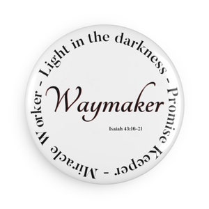 May include: White button with black text that reads "Light in the darkness - Promise Keeper - Miracle Worker - Waymaker" with the scripture reference "Isaiah 43:16-21" underneath.