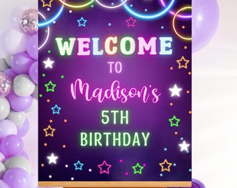 May include: A wooden easel displays a purple sign with the words "WELCOME TO Madison's 5th BIRTHDAY" in neon colors. The sign is decorated with stars and neon circles. Balloons in shades of purple and white are in the background.