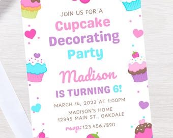 May include: A white invitation with pink, blue, and purple cupcakes and hearts. The text reads "Join us for a Cupcake Decorating Party Madison is turning 6! March 14, 2023 at 1:00PM Madison's Home 12345 Main St., Oakdale RSVP: 123.456.7890"