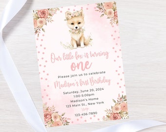 May include: Pink and white first birthday invitation with a cute fox wearing a flower crown. The invitation says "Our little fox is turning one" and includes the date, time, and location of the party.