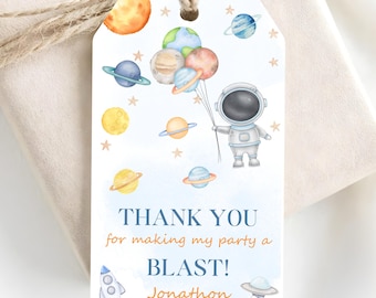 May include: A rectangular gift tag featuring a watercolor illustration of an astronaut holding a cluster of planet-shaped balloons. The text reads: THANK YOU for making my party a BLAST! Jonathon. Includes stars, a rocket, and a flying saucer.