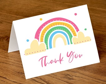 May include: A white thank you card with a colorful rainbow and clouds. The rainbow has pink, yellow, orange, green, blue, and white stripes. The text "Thank You" is written in pink cursive.