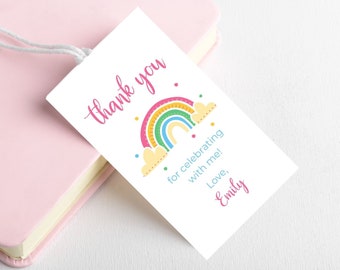 May include: A white thank you tag with a colorful rainbow and clouds. The text reads "Thank you for celebrating with me! Love, Emily".