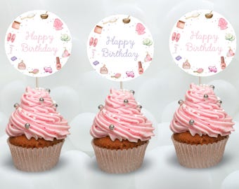 May include: Three pink cupcakes with white frosting and silver sprinkles topped with round white cupcake toppers that say "Happy Birthday" in purple text and feature a spa theme with illustrations of bath products, towels, and cucumbers.
