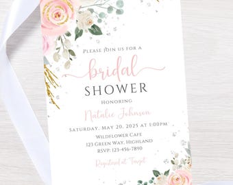 May include: A white invitation card with pink text and floral accents for a bridal shower. The card features the words "bridal shower" in a cursive font, along with the honoree's name, date, time, and location. Gold glitter and floral elements decorate the corners.