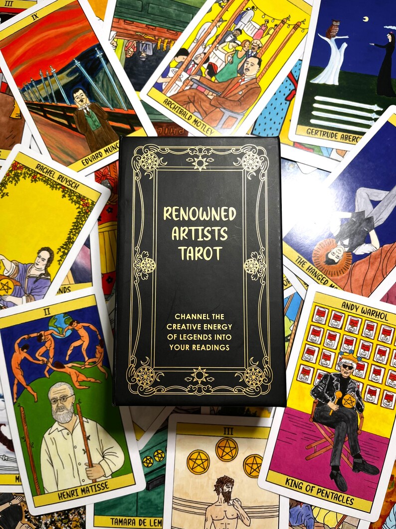May include: A black tarot card box with gold lettering that reads "Renowned Artists Tarot." The box is surrounded by tarot cards featuring artwork and the names of famous artists like Andy Warhol and Henri Matisse. The cards have colorful illustrations.