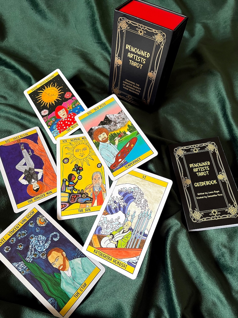 May include: A tarot card deck and guidebook with the text "Renowned Artists Tarot". The cards feature artwork inspired by famous artists like Van Gogh and Hokusai. The box and guidebook are black with gold accents, and the cards are displayed on a green fabric.