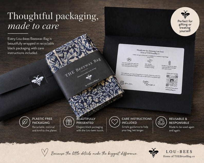 May include: A folded beeswax bag with a dark blue and cream floral pattern, wrapped in a black paper band labeled THE BEESWAX BAG. It is presented with a black envelope containing care instructions, a bee logo, and text about sustainable packaging.