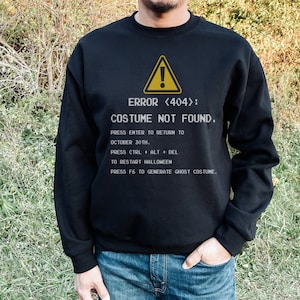 May include: Black sweatshirt with a white graphic of a computer error message that says "ERROR <404>: COSTUME NOT FOUND." The graphic also includes instructions for how to fix the error.