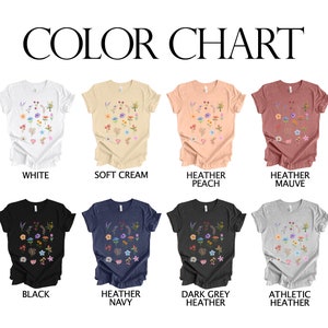 May include: Color chart showing 10 different t-shirt colors with a floral design. The colors are white, soft cream, heather peach, heather mauve, black, heather navy, dark grey heather, and athletic heather.