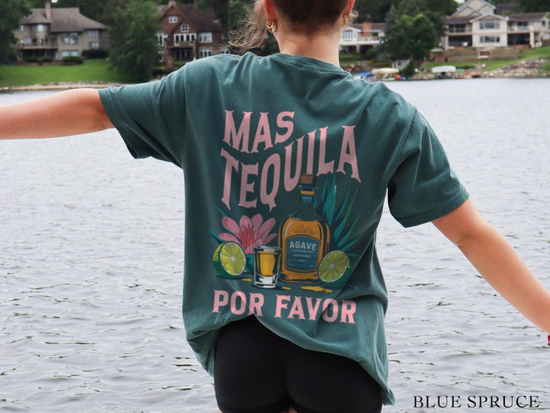 May include: A teal blue t-shirt with a pink graphic that says "Mas Tequila Por Favor" and features a bottle of tequila, a shot glass, and limes.