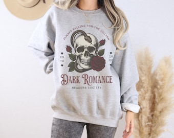 May include: Gray sweatshirt with a skull and snake graphic. The text "Always Falling for the Villain" is above the graphic and "Dark Romance Readers Society" is below the graphic.