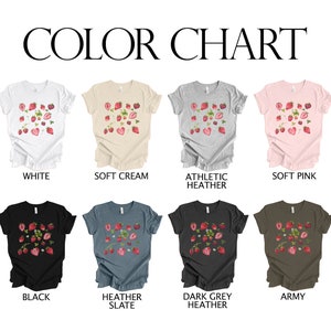 May include: Colour chart displaying ten different t-shirt colours with a strawberry graphic print. The colours are white, soft cream, athletic heather, soft pink, black, heather slate, dark grey heather, and army.