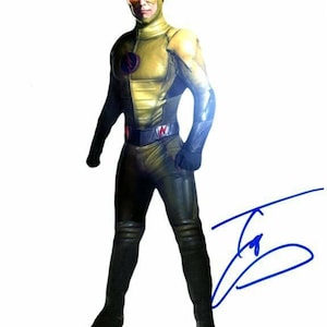 May include: A yellow and black superhero costume with red eyes. The costume is signed by the actor who played the character. The signature is in blue ink.