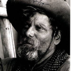 May include: Black and white photo of a man with a beard and mustache wearing a cowboy hat. The hat has the signature "Stephen Lang" written on it.