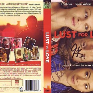 May include: DVD cover for the romantic comedy film "Lust for Love" featuring a red and white checkered shirt, a blue shirt, and a close-up of the actors' faces. The title of the film is in large red letters. The DVD cover also includes a list of bonus features and a website address.
