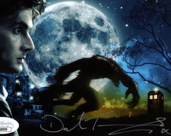 May include: A black and white image of a werewolf running towards a blue TARDIS. The werewolf is silhouetted against a full moon. The image is signed "David Tennant" in black ink.