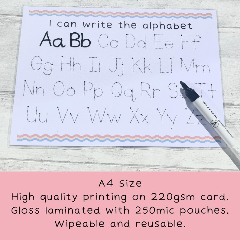 May include: A white laminated A4-sized card with dotted lines for tracing the alphabet. The card has a pink and blue wavy border. The text "I can write the alphabet" is at the top of the card. A black dry-erase marker is lying on the card.